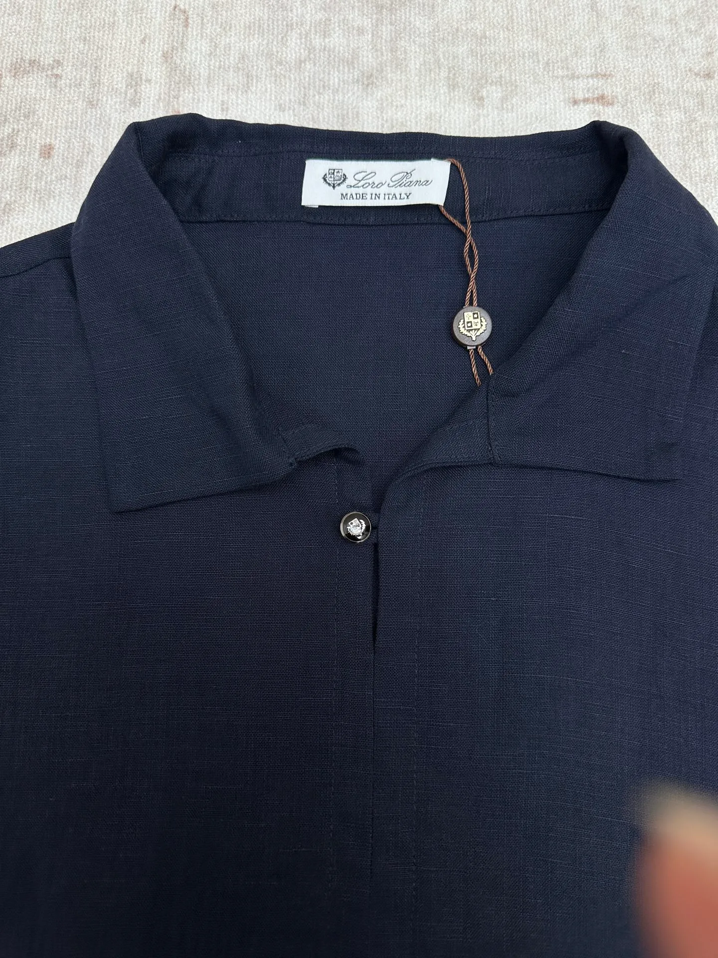 LP 26 New Arrival linen short-sleeved Polo shirt is a light luxury item made in Italy. It features a relaxed and elegant "old money style" tone, and uses simple design and natural fabrics to interpret the high-end feel of summer. The style adopts a Classic small lapel + single-button half placket design, which is neat and casual. It is matched with a slightly loose straight cut and a short-sleeved silhouette, taking into account comfort and neat lines. It does not flatter the body shape and hides the muscles to look slimmer. Available in navy blue and white, it is suitable for a variety of wearing scenarios, whether it is daily casual or light business occasions. The fabric is made of 100% linen, with natural texture and breathable holes. It has excellent moisture absorption and heat dissipation. It is dry and not sweaty when worn in summer, and has a natural drape when worn. It is an ideal choice for summer commuting and vacation. There is no unnecessary decoration on the whole, and the fabric texture and neat tailoring are the key to winning. It is low-key and durable, and can easily create an effortless high-end outfit. Sizes: M.L.XL.XXL.